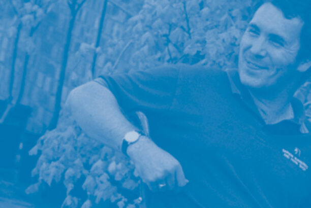 Man in his 40s in a manual wheelchair in a garden, smiling