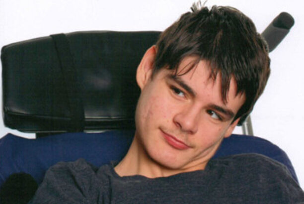 Young dark haired man with disabilities in a wheelchair, smiling