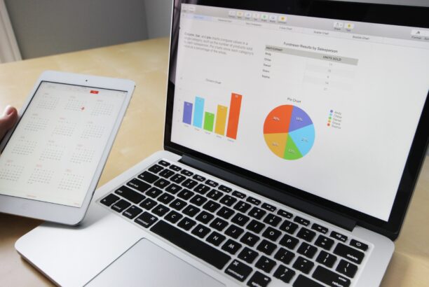 Laptop and tablet on a table showing a report with graphs and pie charts